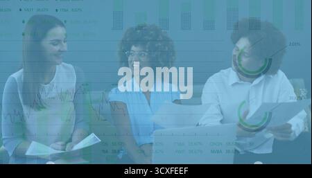 Reviewing three professionals in workwear discussing printed documents and tablet in office lounge Stock Photo