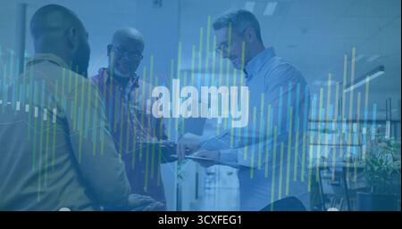 Analyzing three professionals wearing business attire using tablet in office with digital charts Stock Photo