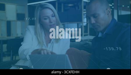 Collaborating colleagues analyzing data overlay on laptop at coffee table in office lounge Stock Photo