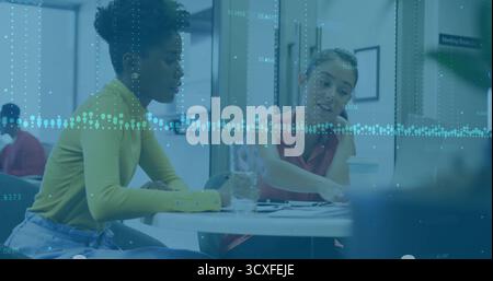Two office colleagues collaborating on charts in office common area, with digital overlay Stock Photo