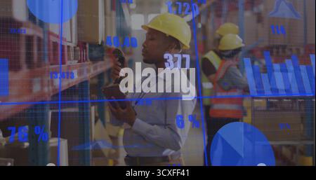 Using barcode scanner, worker wearing hard hat scanning box in warehouse aisle, with analytics Stock Photo