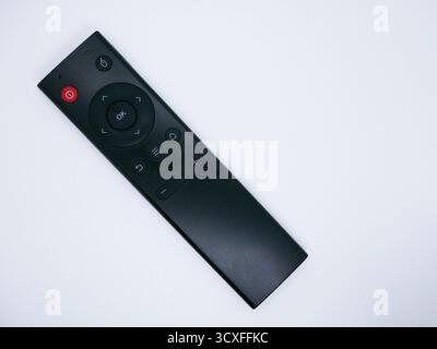 A black remote control with various buttons on a white background. The remote is sleek and modern, designed for easy use with electronic devices. Stock Photo