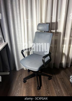 Ergonomic comfortable office computer chair in grey color. Front view. Stock Photo