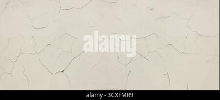 Cracked peeling white paint creating abstract wall texture Stock Photo