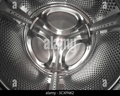 Clean stainless steel drum interior of a modern washing machine with perforated surface Stock Photo
