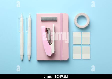 Stapler and other stationery on light blue background, flat lay Stock Photo
