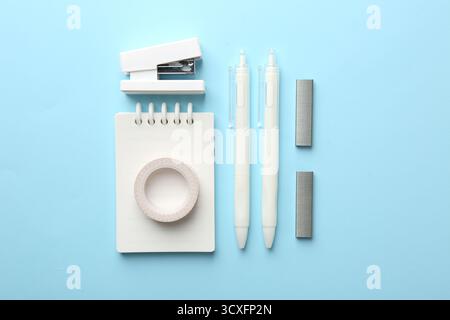 Stapler and other stationery on light blue background, flat lay Stock Photo