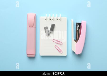 Stapler and other stationery on light blue background, flat lay Stock Photo