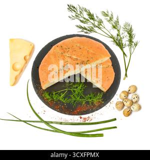 A delightful flat lay featuring sliced focaccia bread seasoned with herbs on a dark slate, surrounded by Swiss cheese, quail eggs, and fresh dill. Stock Photo