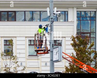Moscow, Russia, September 29, 2025: Two qualified specialists perform maintenance or installation of complex equipment on a city communications tower. Stock Photo