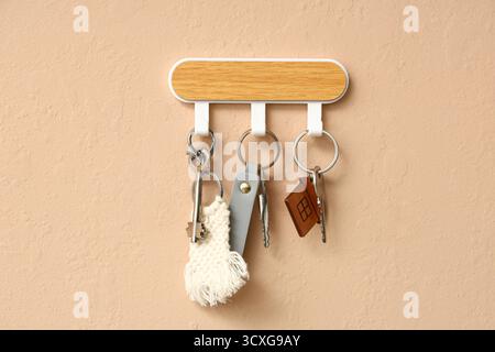Rack with keys from house on beige wall Stock Photo