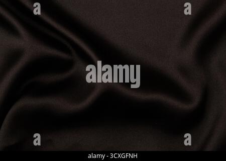 Elegant black satin silk fabric material with subtle draperies. Top view Stock Photo