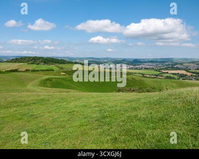 Rolling green hills and countryside view across Dorset with town in valley below Stock Photo