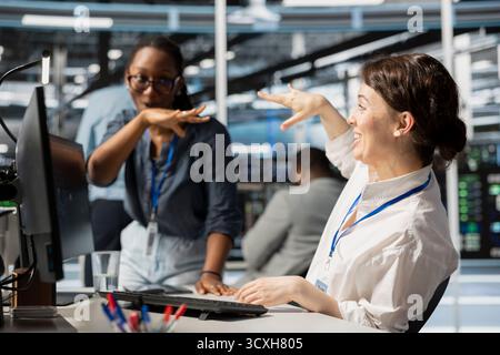 Happy data center colleagues in good mood after after successfully improving system efficiency metrics. Excited engineering team pleased by enhanced network infrastructure performance Stock Photo
