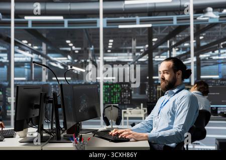 Data center admin running diagnostic scripts on computer, examining infrastructure. Server room IT expert using PC to evaluate performance metrics, running tests to maintain system stability Stock Photo