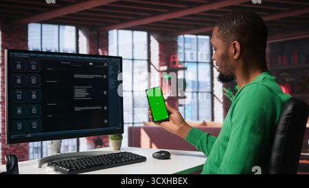 Black guy interacting with intelligent AI chatbot on pc next to copy space screen, using smart innovative system. Machine learning enhances efficiency through advanced algorithms. Camera B. Stock Photo