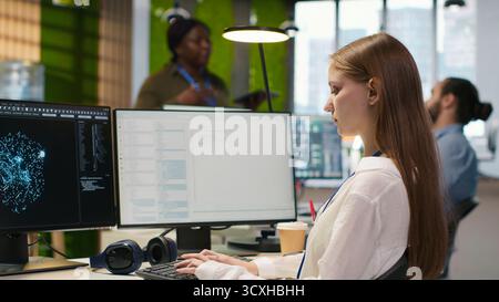 Female technician testing generative AI machine learning algorithms at work. IT professional scaling productivity with artificial intelligence large language model written code, camera A Stock Photo