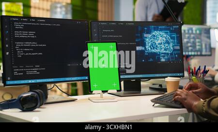 Admin using isolated screen tablet to code AI algorithms debugging software issues and improving system stability. Tech startup office worker using chroma key device, configuring settings, camera A Stock Photo