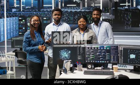 Portrait of smiling data center technicians analyzing infrastructure issues using node tree tools. Happy server hub specialists review AI visualization insights to optimize system health, camera A Stock Photo