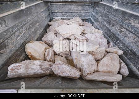Stone samples displayed in metallic bin in various sizes and hues Stock Photo