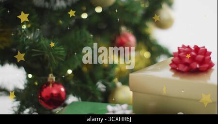 Christmas tree with ornaments and gift boxes over falling stars image Stock Photo