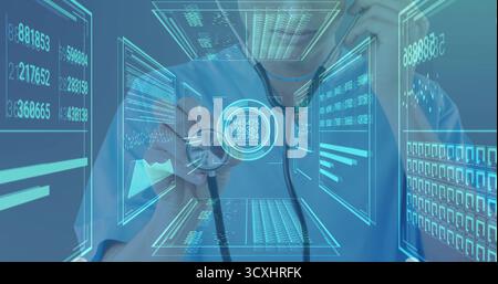 Doctor wearing scrubs examining patient metrics on data panels in clinic, with stethoscope in hand Stock Photo