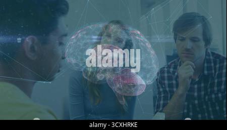 Presenting professionals analyzing holographic brain model at meeting table, with glowing network Stock Photo