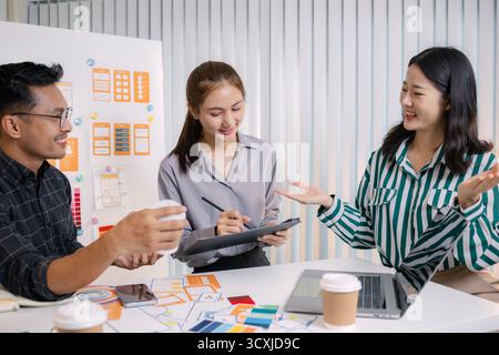 UX/UI designers collaborating during a creative workshop to test interface ideas and exchange feedback for app development, emphasizing teamwork and i Stock Photo