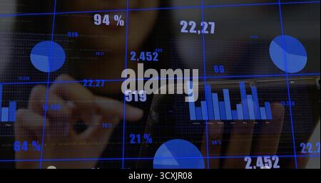 Interacting data analyst wearing jacket tapping touchscreen display in office, with floating charts Stock Photo