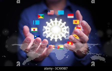 Hands holding world map with international flags and glowing network icon symbolizing teamwork, unity, and cooperation among global nations for busine Stock Photo