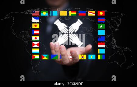 Concept of international cooperation showing hands connected in unity over global map, representing teamwork, trust, diversity, and global partnership Stock Photo