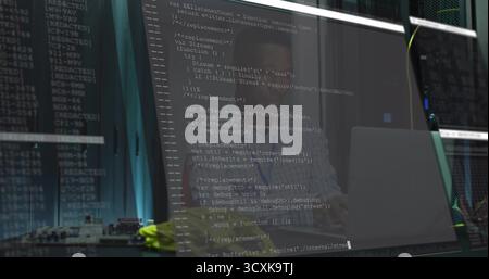 Typing African American developer coding JavaScript in server room, with monitor and server racks Stock Photo
