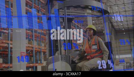 Worker in hard hat and safety vest steering control in warehouse, with digital graphics, copy space Stock Photo