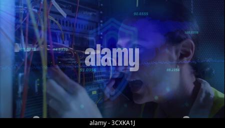 Adjusting cables, technician wearing safety vest talking on phone in server room, floating graphics Stock Photo