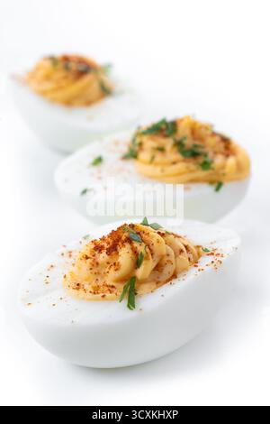 Homemade hard Boiled Deviled Eggs garnished with herbs isolated on white background Stock Photo
