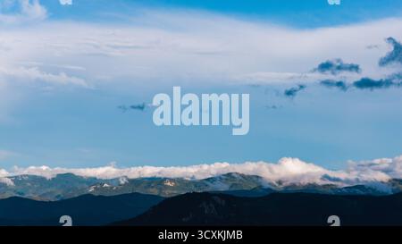 Panoramic mountain landscape under blue sky with scattered clouds Stock Photo