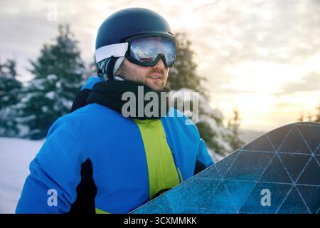 Snowboarder Of Man On The Background Blue Sky,  Hold Snowboard. Wearing Ski Glasses. Stock Photo