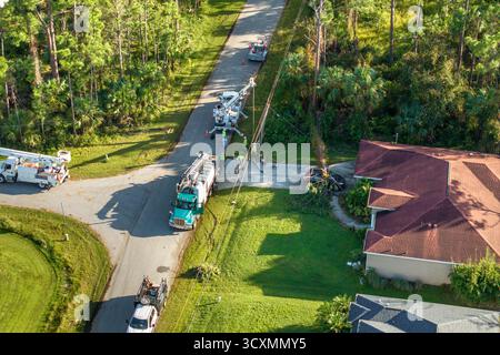 Electricity outage fixing after hurricane in Florida. Electrician workers repairing damaged power lines Stock Photo