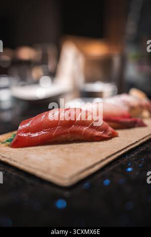 Close up nigiri sushi with glossy tuna on wooden board in Japan Stock Photo