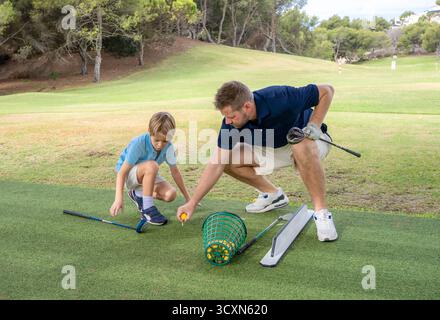 Father and little son playing golf at the golf course. Stock Photo
