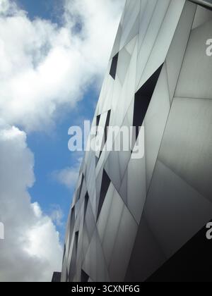 Modern Geometric Facade with Silver Panels and Sky Stock Photo
