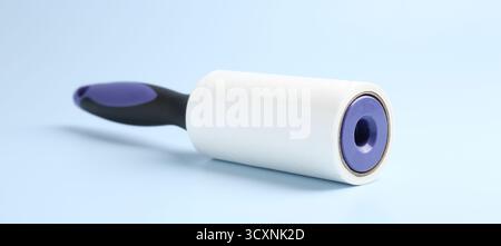 One lint roller on light blue background, closeup Stock Photo
