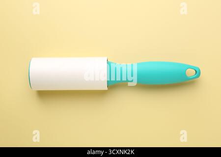 One lint roller on yellow background, top view Stock Photo