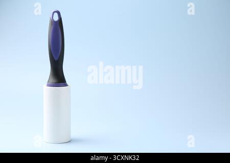 One lint roller on light blue background, space for text Stock Photo