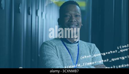 Standing engineer wearing sweater and badge in data center corridor, server racks and code overlay Stock Photo