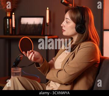 Host with headphones recording podcast in studio Stock Photo