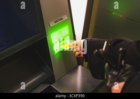 Client inserting credit card into ATM banking machine Stock Photo
