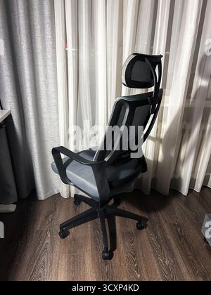 Ergonomic comfortable office computer chair in grey color. Side view. Stock Photo