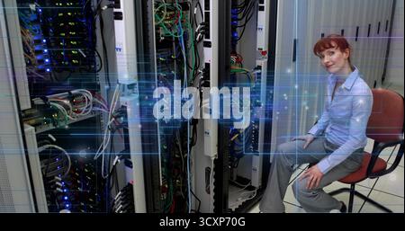 Technician in blue work clothes monitoring traffic in data center, with digital overlay, copy space Stock Photo