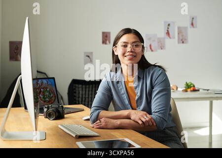 Portrait of Woman Smiling While Sitting at Desk Working Stock Photo